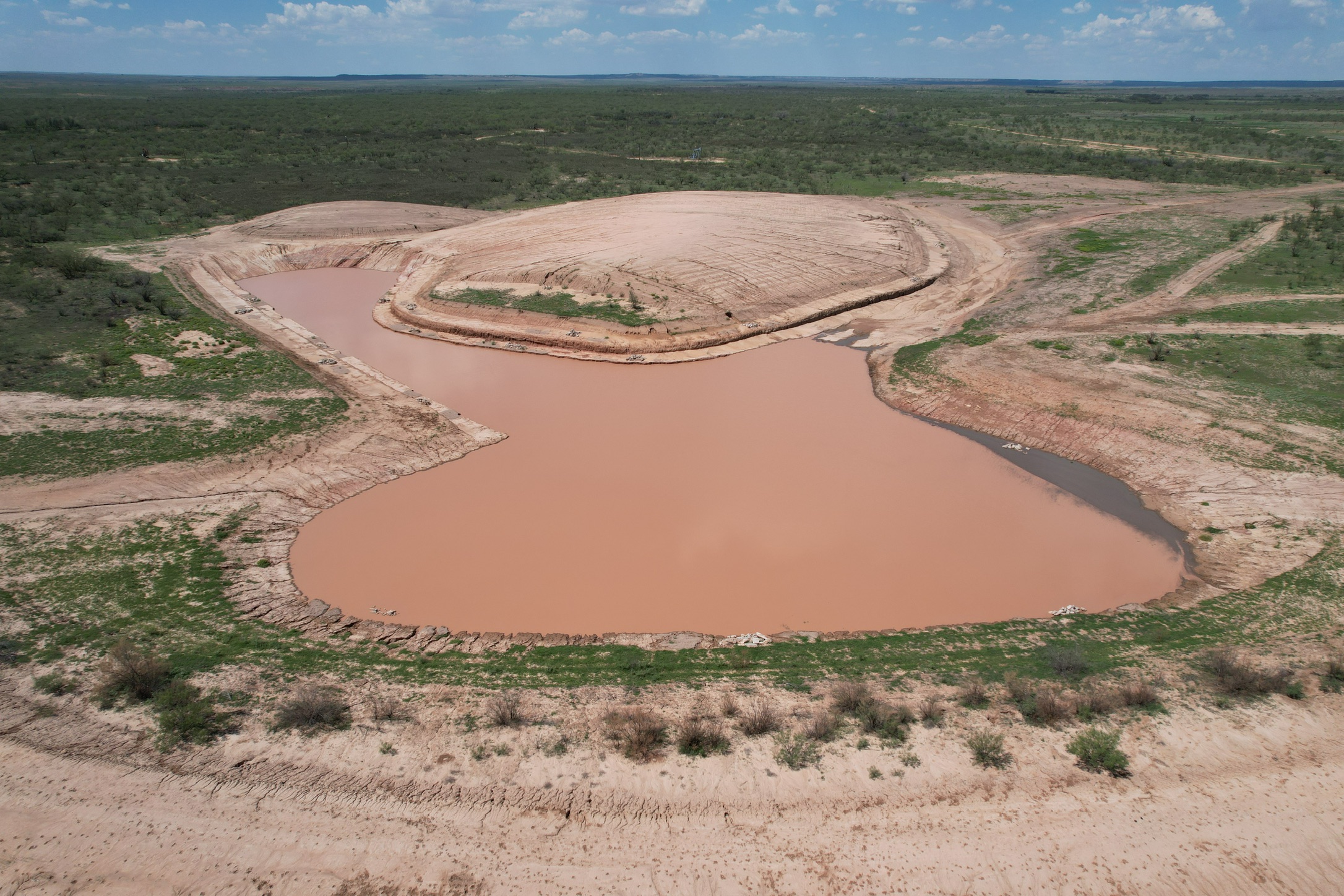 Aerial view of a completed 25-acre reservoir with a rebuilt dam, shelving and fish structure on a private ranch in Garza County, Texas.